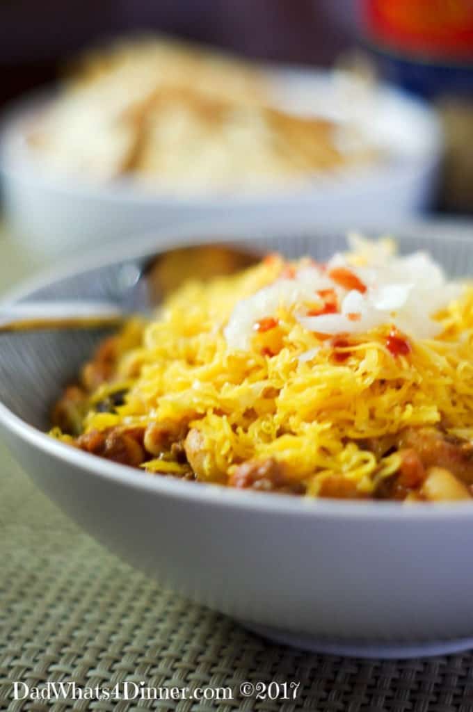white bowl of chili Mac topped with cheese