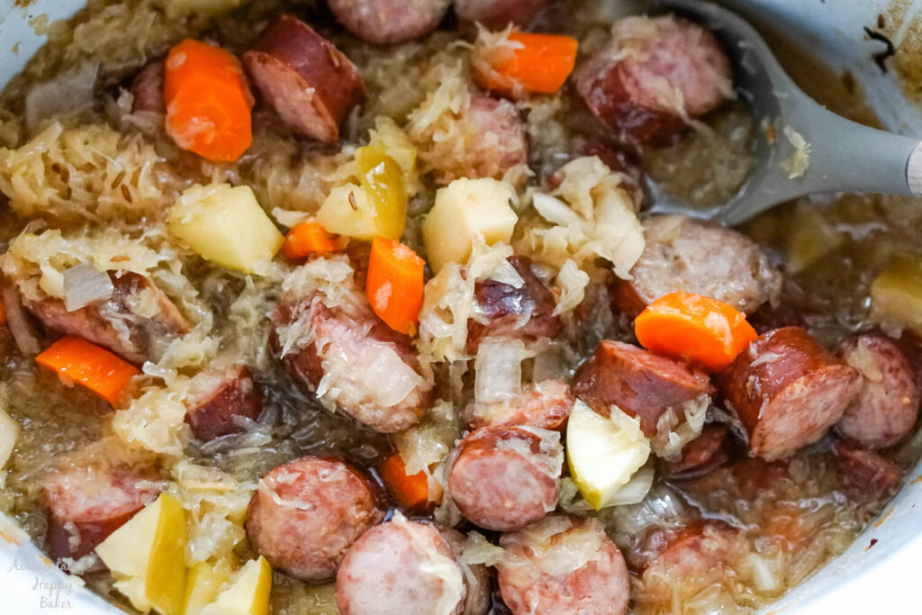 A crockpot of cooked kielbasa and sauerkraut. 