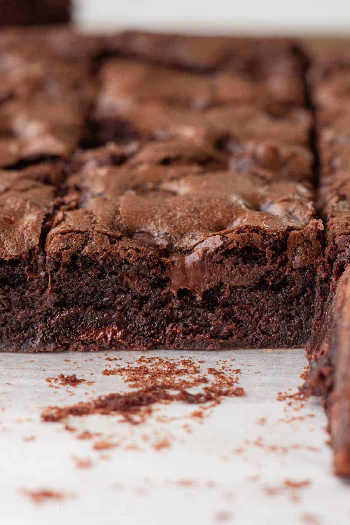 Baked sourdough brownie slice on parchment paper.