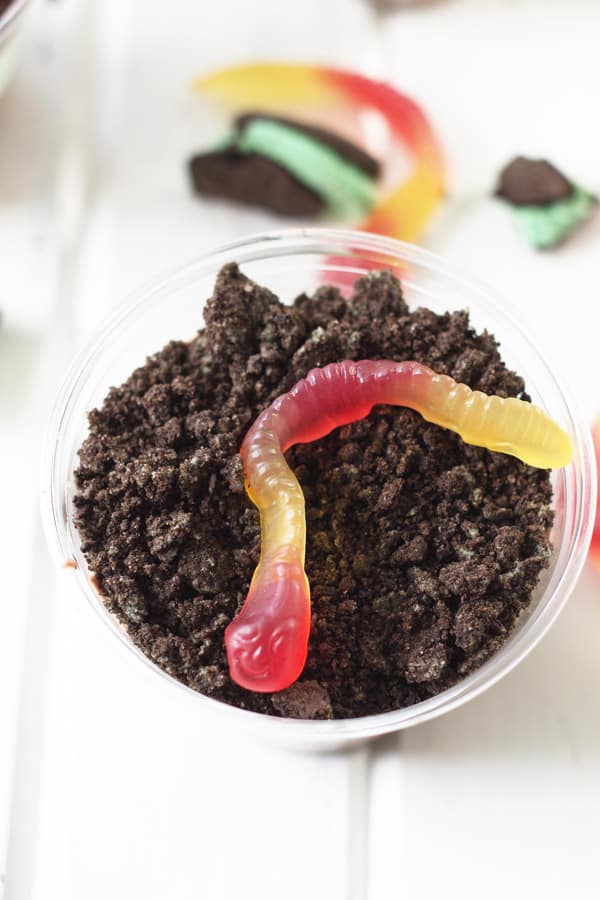 an overhead shot of a dirt cup showing the oreo "dirt" and gummy worms