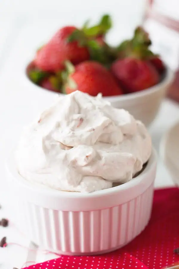 closeup: a ramekin full of homemade strawberry whipped cream for strawberry waffles