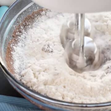 Dry mixture being mixed with the wet mixture in glass bowl.