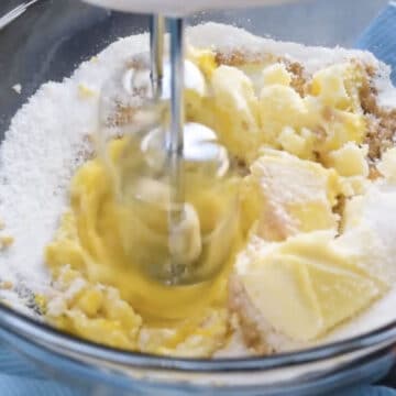 Creaming together butter, eggs, Splenda and vanilla in glass bowl.
