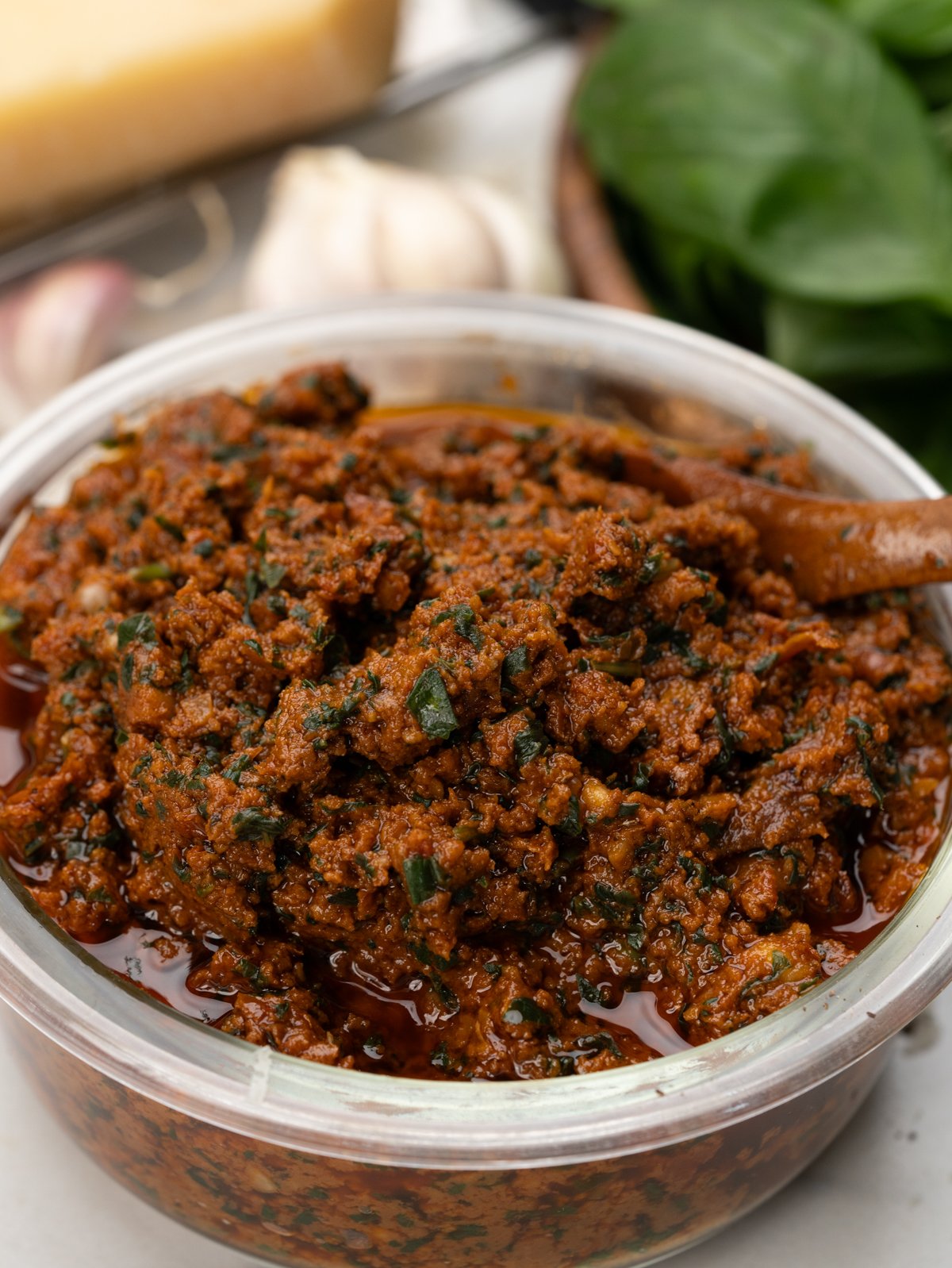 A bowl of chunky, herby, sun-dried tomato pesto.