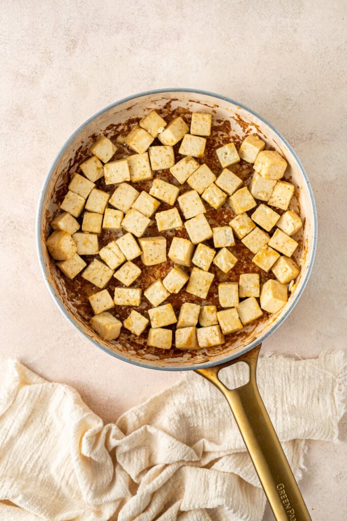 Cooking the cubed tofu in a frying pan.