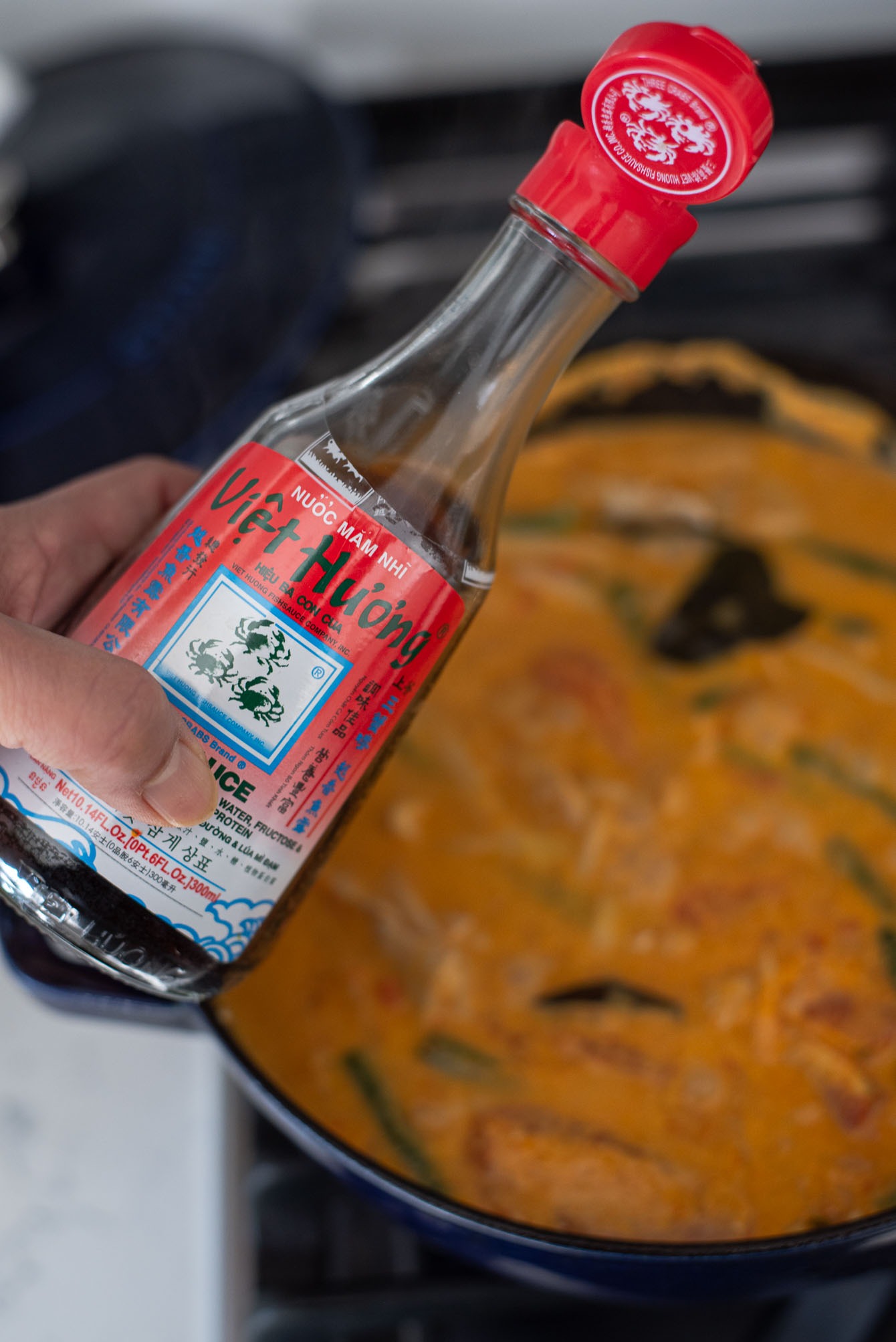 Fish sauce added to season Thai red curry chicken.