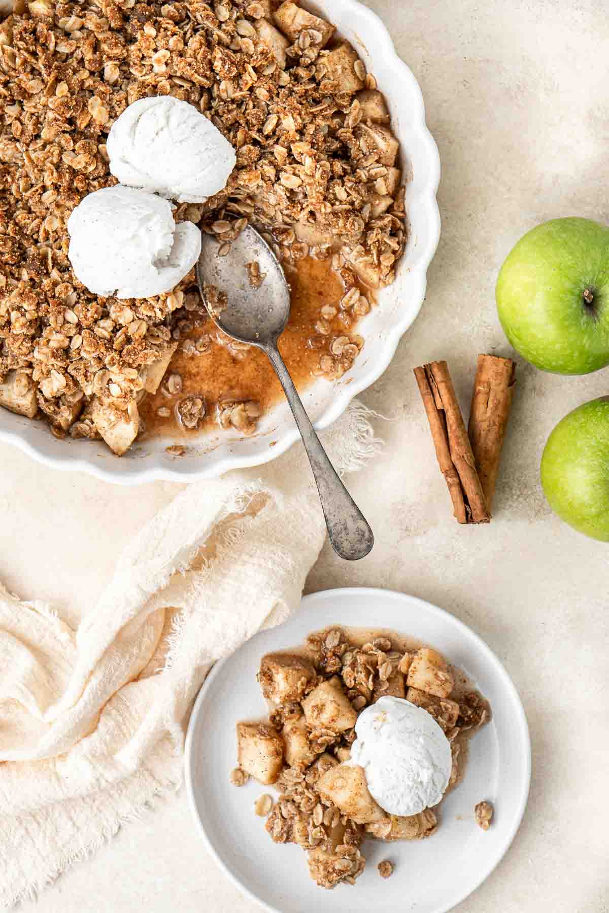 Apple crumble served onto a plate with vanilla ice cream.