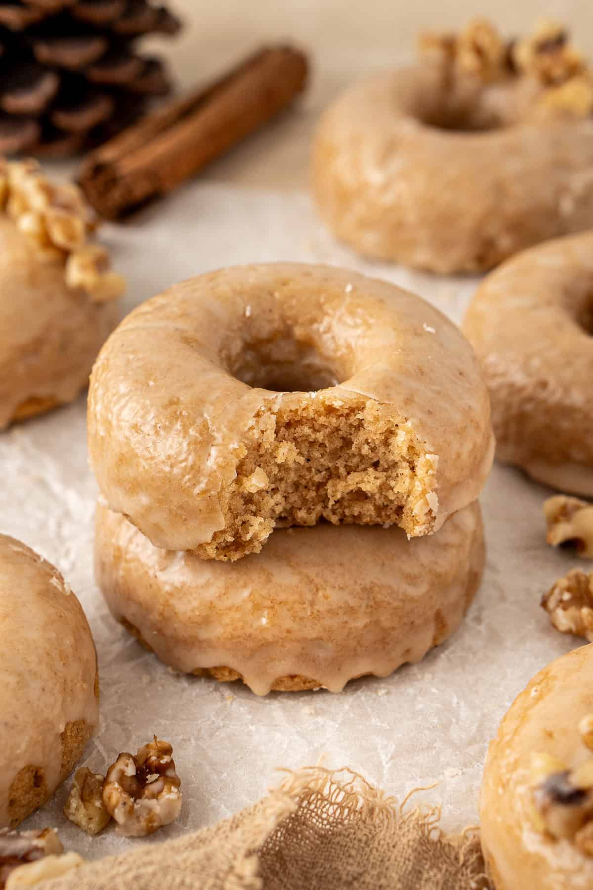 Two maple glazed doughnuts, one with a bite taken.