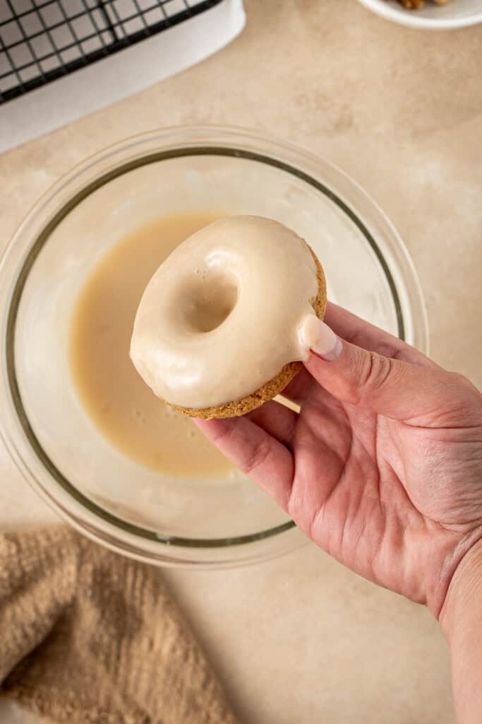 Dunking the doughnut in the maple glaze.