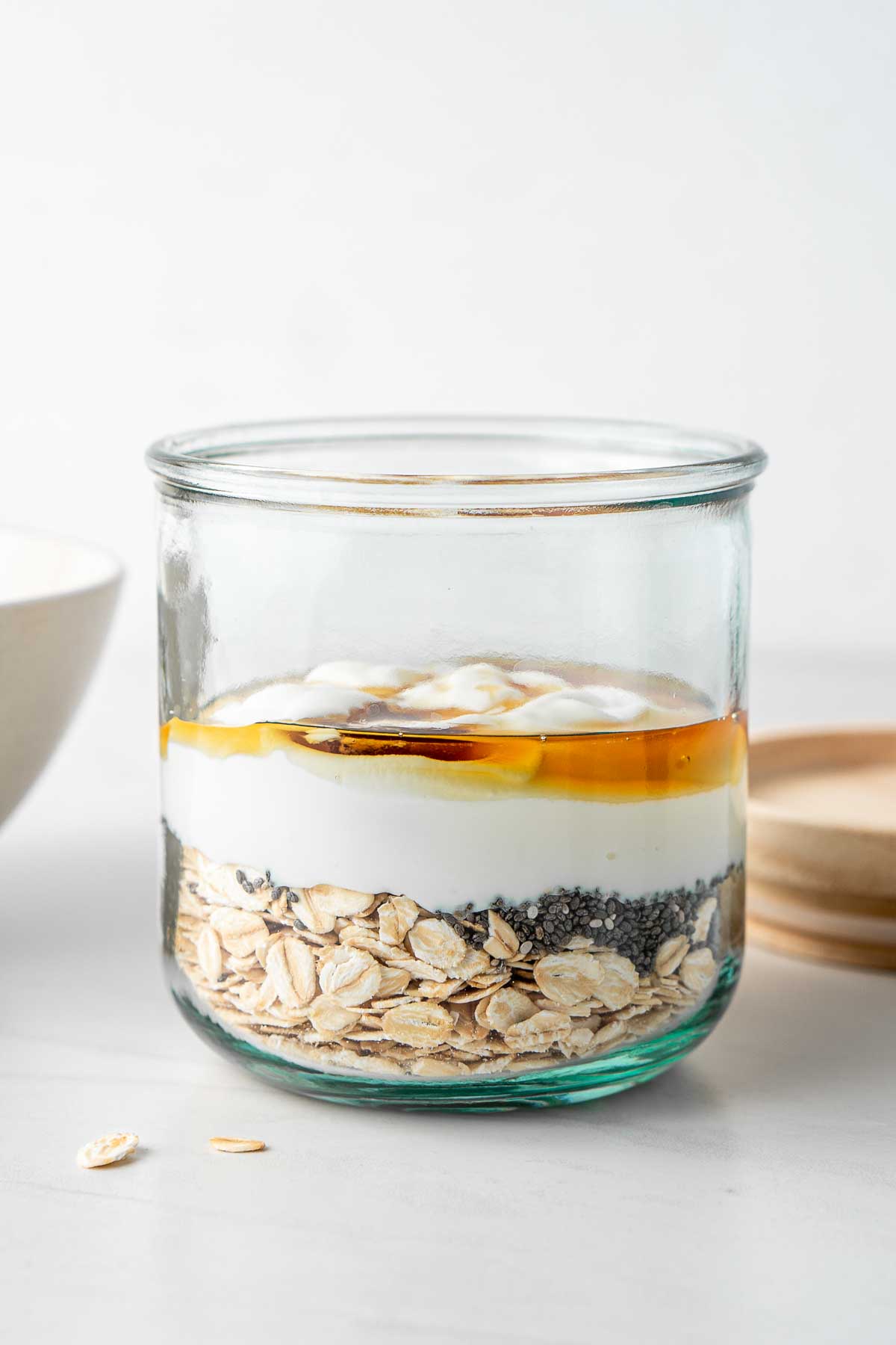 Adding all ingredients to a jar to make overnight oats.