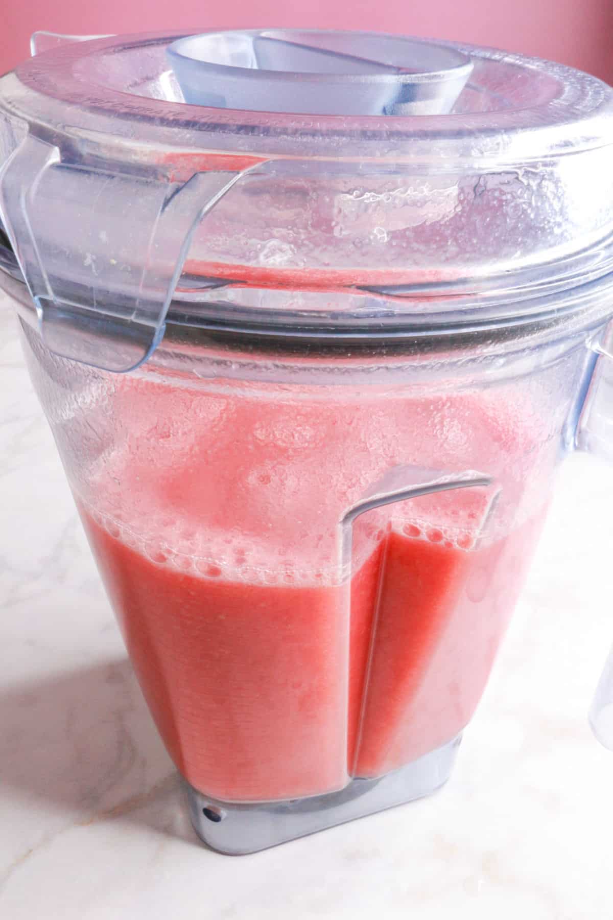 Blended strawberry and watermelon agua fresca in a blender