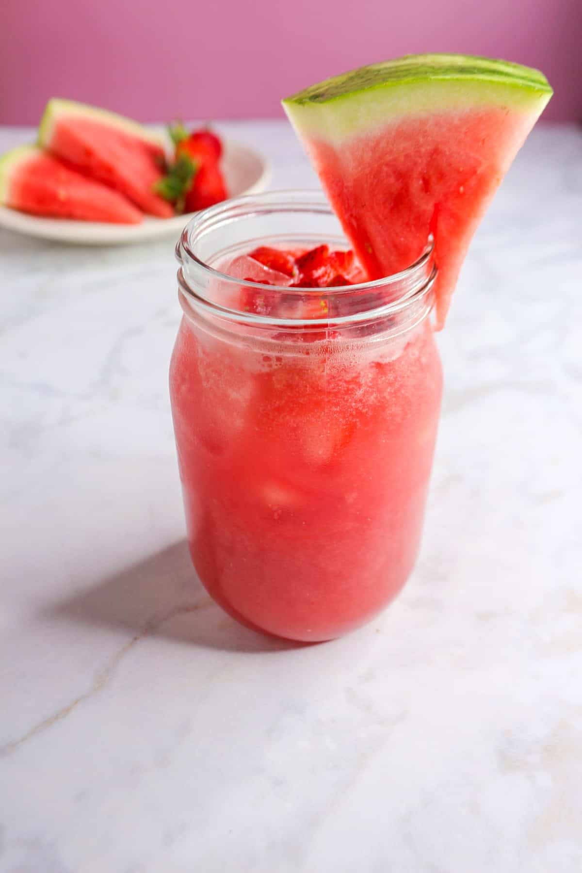 Watermelon Strawberry Agua Fresca in a glass garnished with a slice of watermelon
