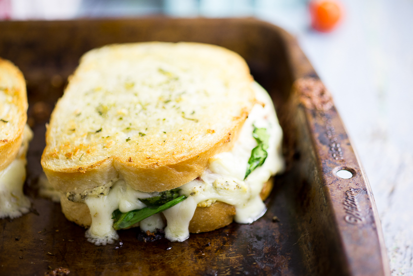 Oven Baked 5 Cheese White Pizza Grilled Cheese Recipe - Baked in the oven to golden, gooey perfection, this deluxe 5 Cheese White Pizza Grilled Cheese is the ultimate cheesy sandwich with 5 types of real cheese, a garlic herb ricotta spread, garlic butter, tangy cherry tomatoes and spinach. 