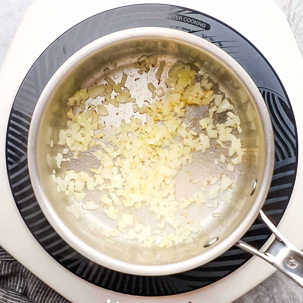onions being cooked in a pot