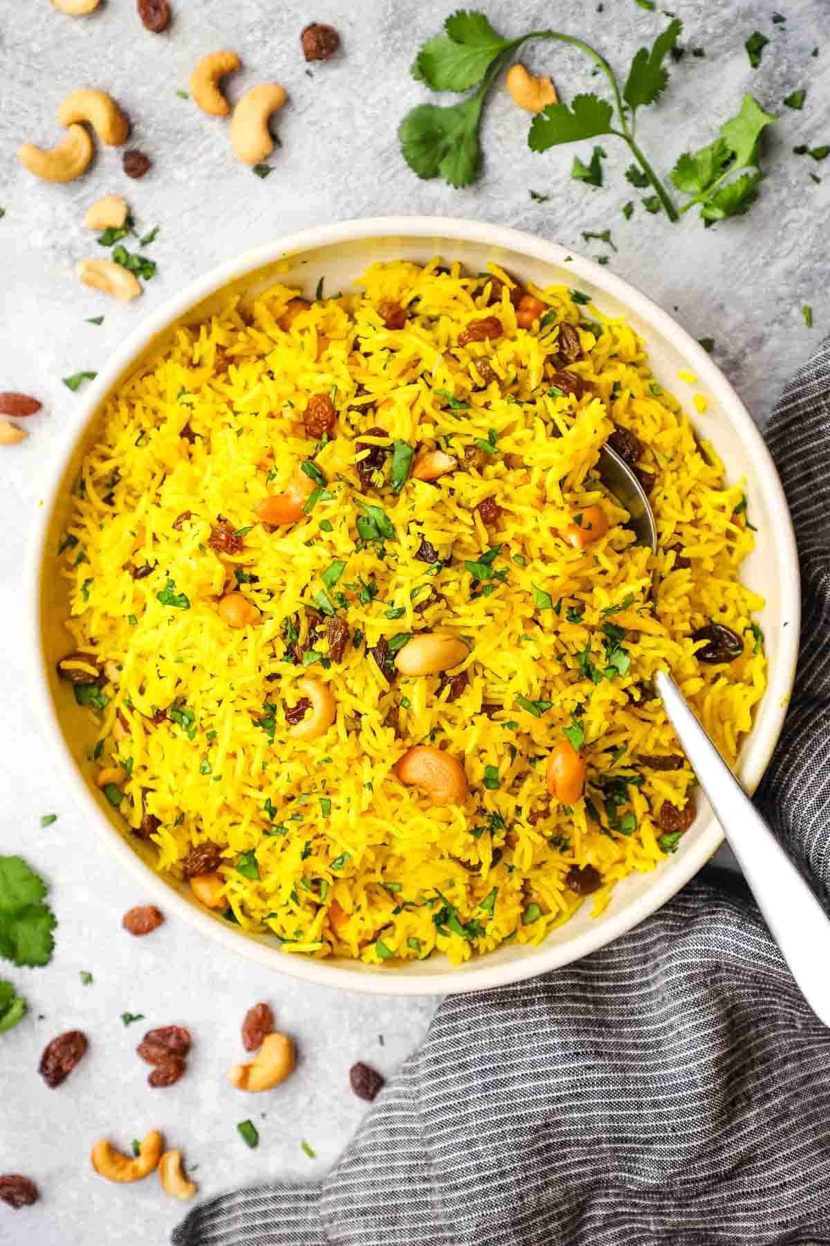 a dish of yellow basmati rice in a dish with a spoon in it