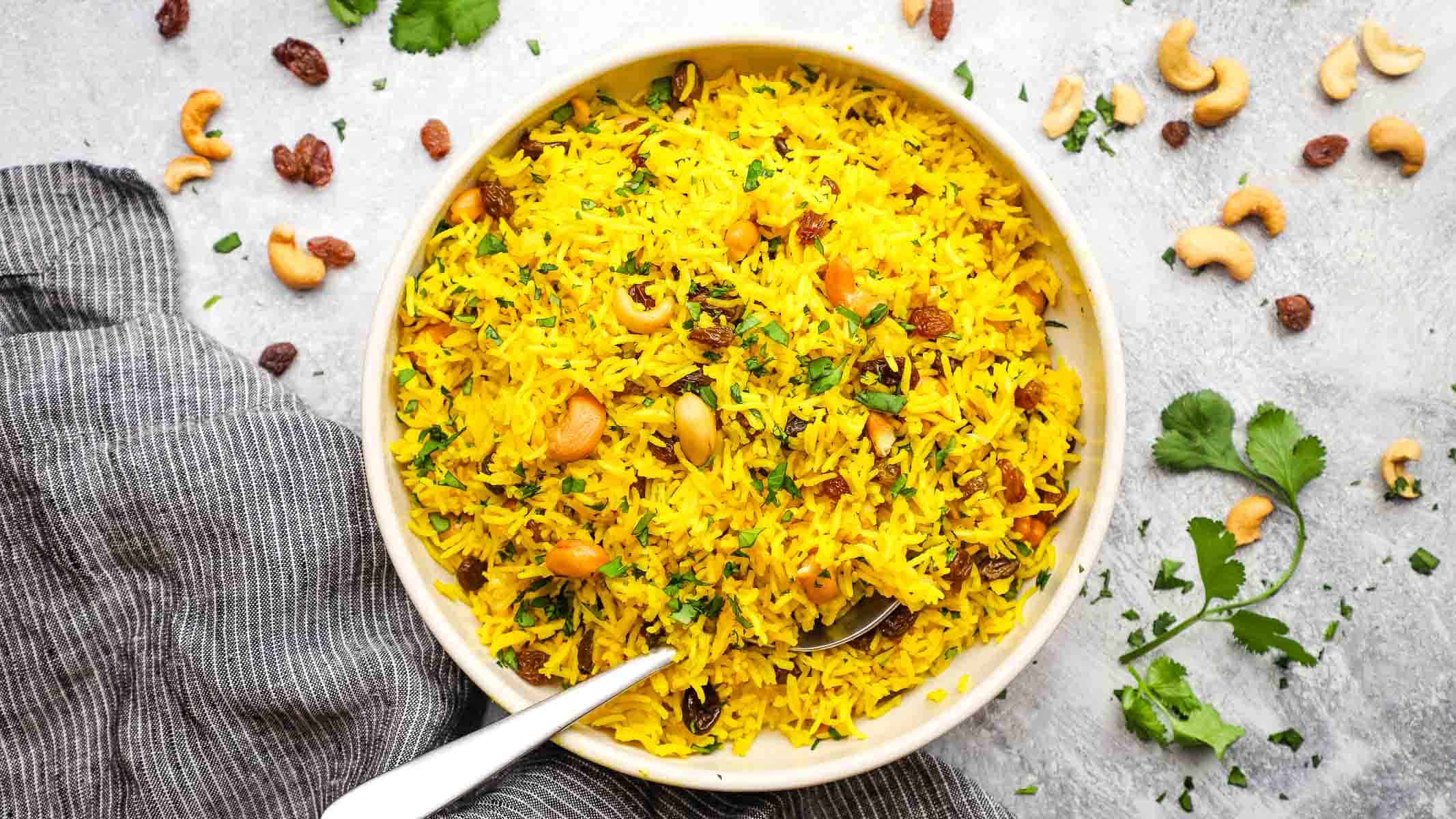 a dish of yellow basmati rice in a spoon