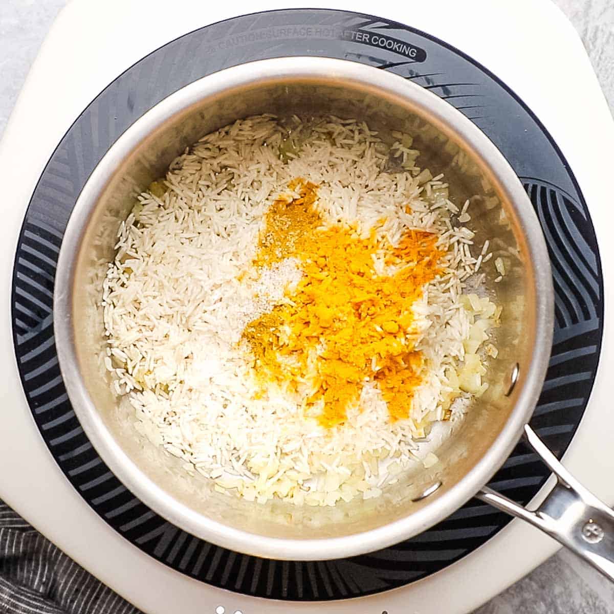 basmati rice, curry powder, turmeric, and salt added to the pot