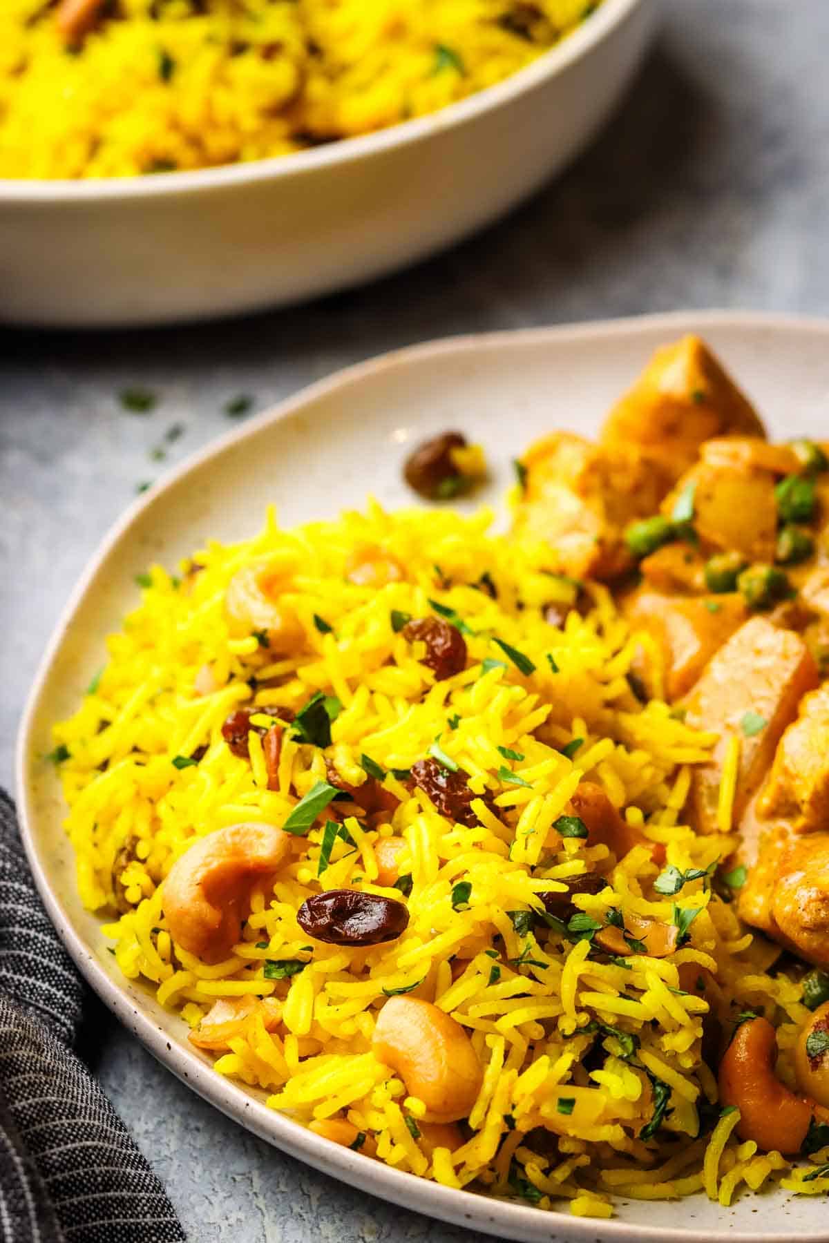 yellow basmati rice served in a plate with a curry