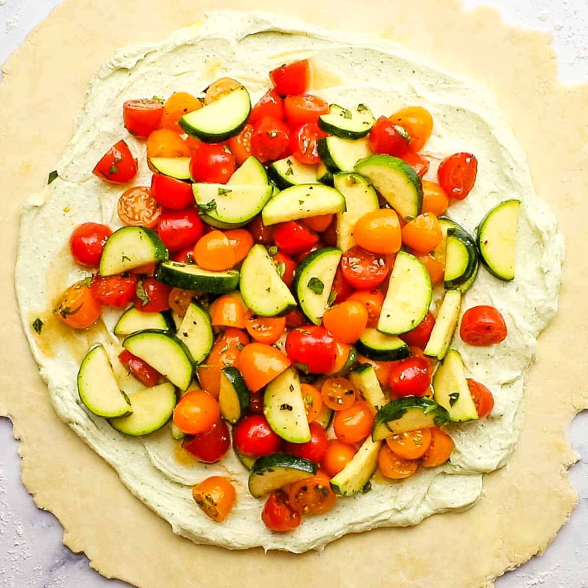 spreading out vegetables on the whipped out feta mixture