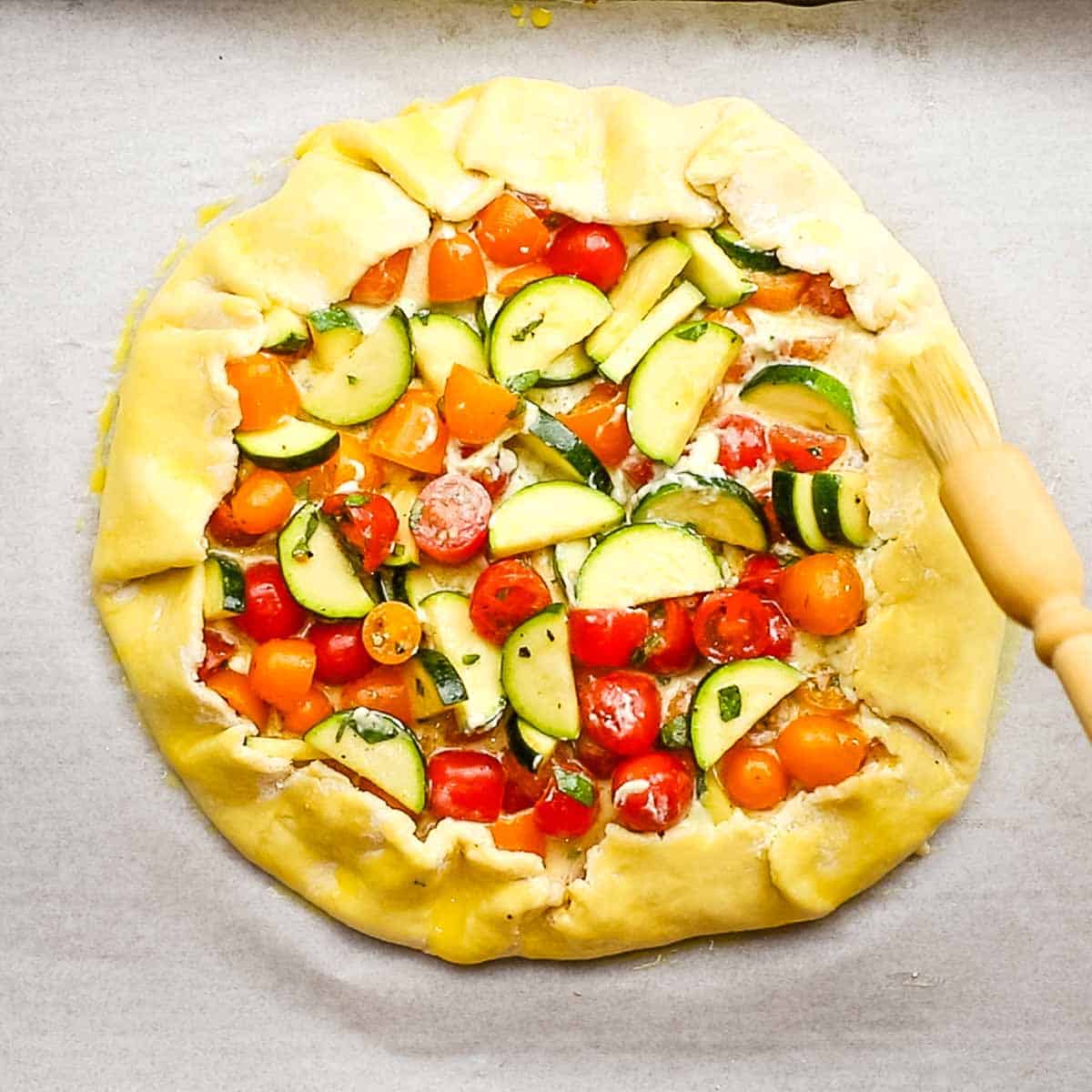 brushing egg wash on the exposed pie crust