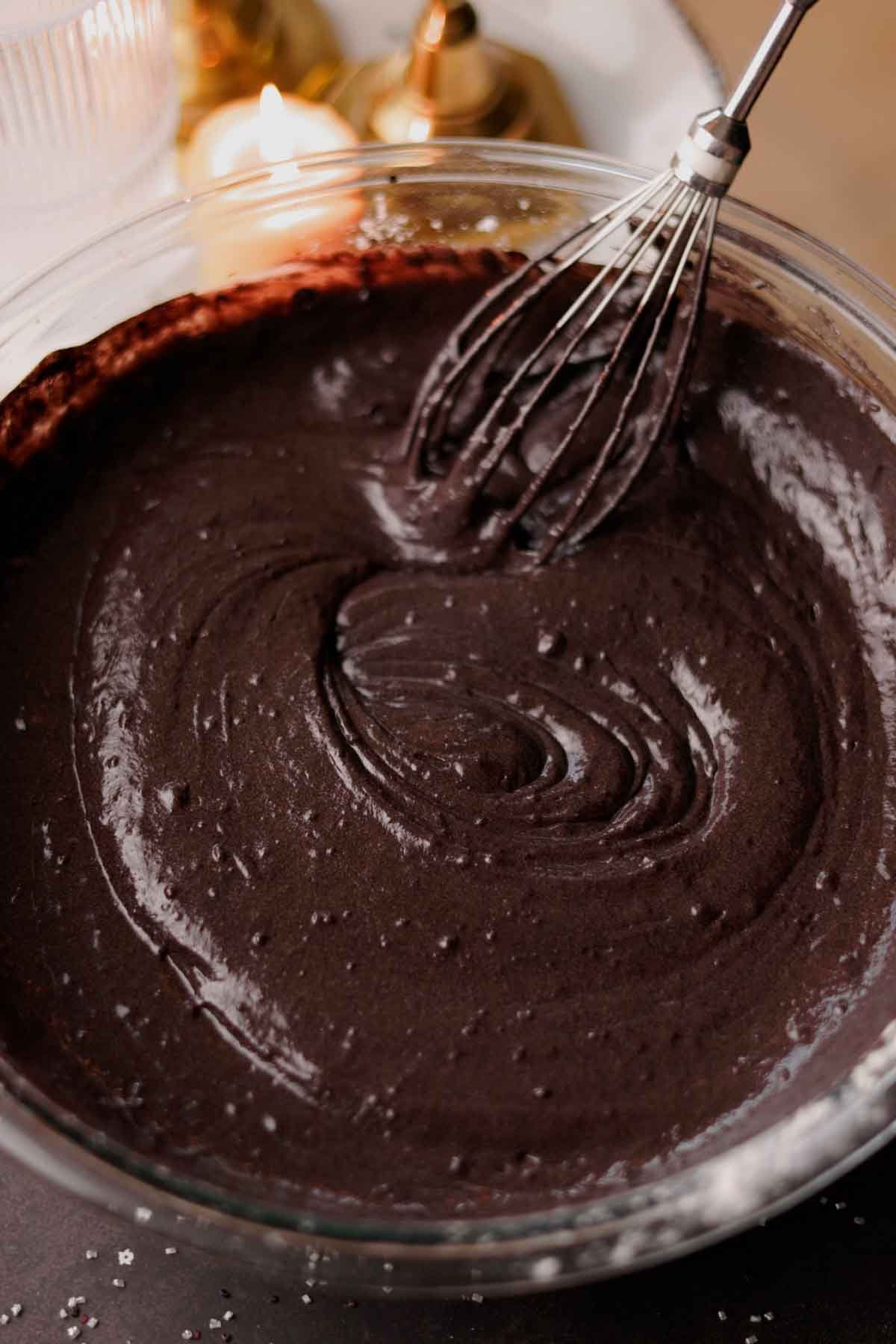 folding black velvet cake batter with a whisk