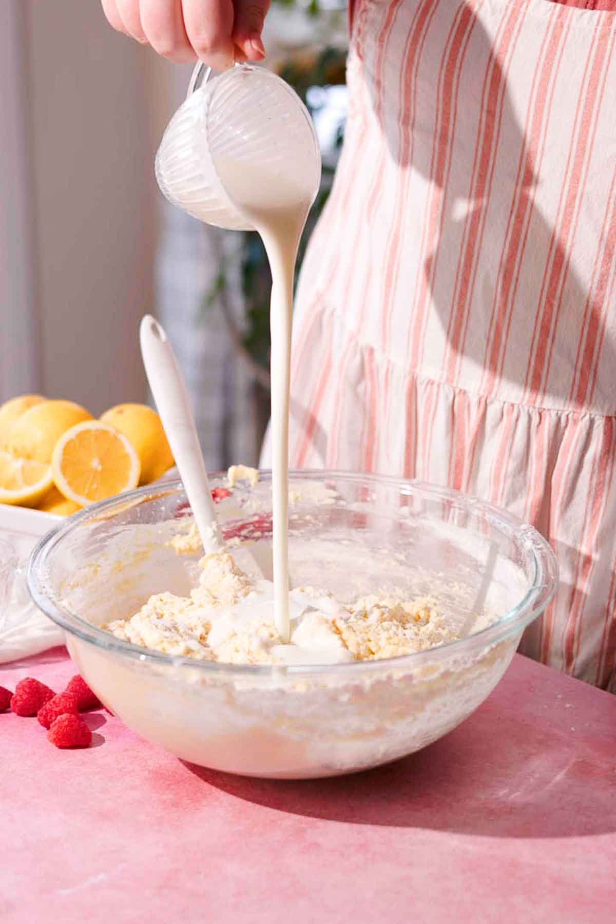 pouring buttermilk into large bowl full of cake batter