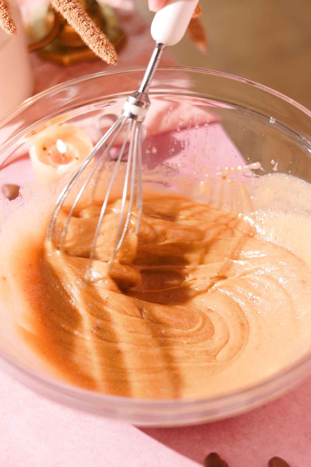 whisking butter, eggs, and sugar with a wire whisk until creamy and lightened in color