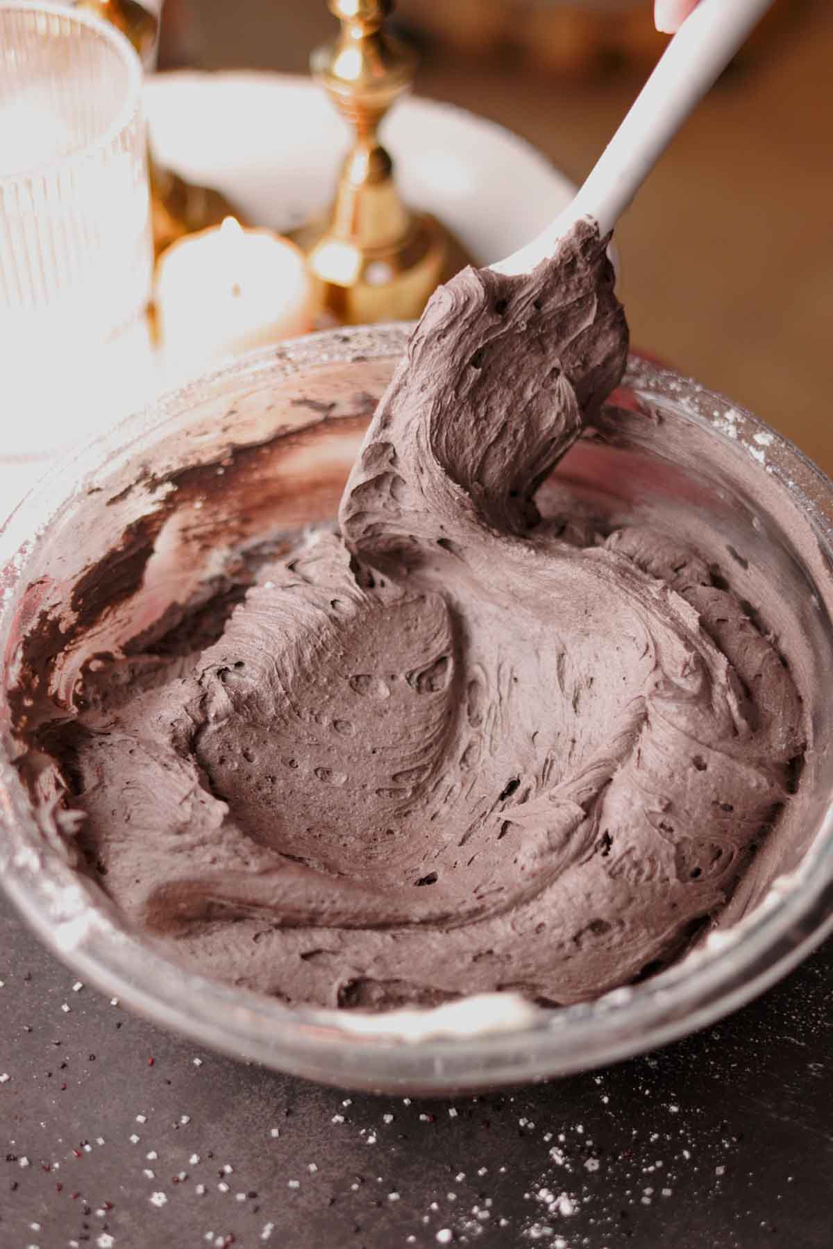 folding black frosting with a spatula