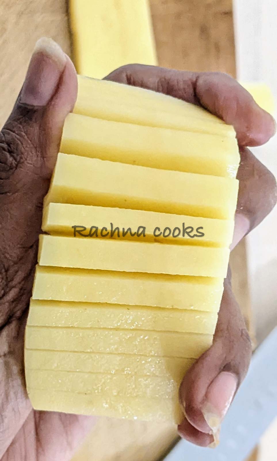 Potato cut to form accordion. Held in hand.