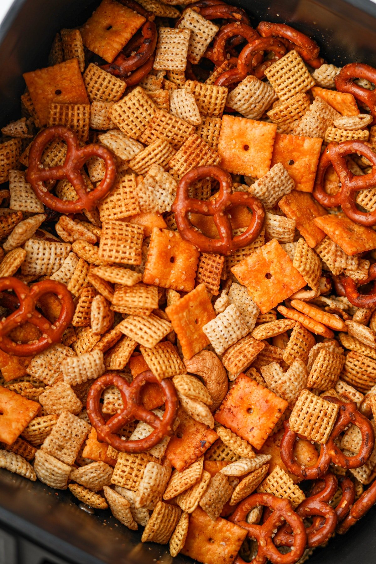 A close up on Chex mix, featuring pretzels, cheez-its, and Chex cereal.