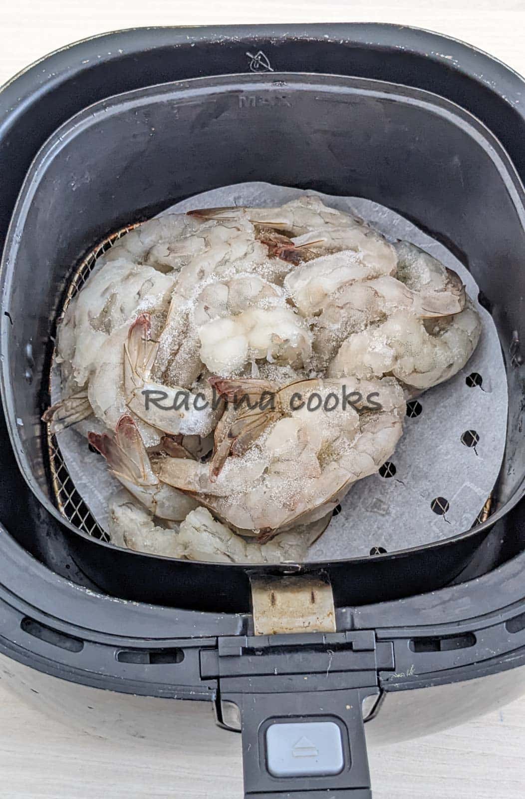 frozen raw shrimp placed in air fryer basket.