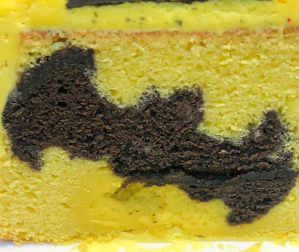 batman shaped cake cutout inside a yellow cake.