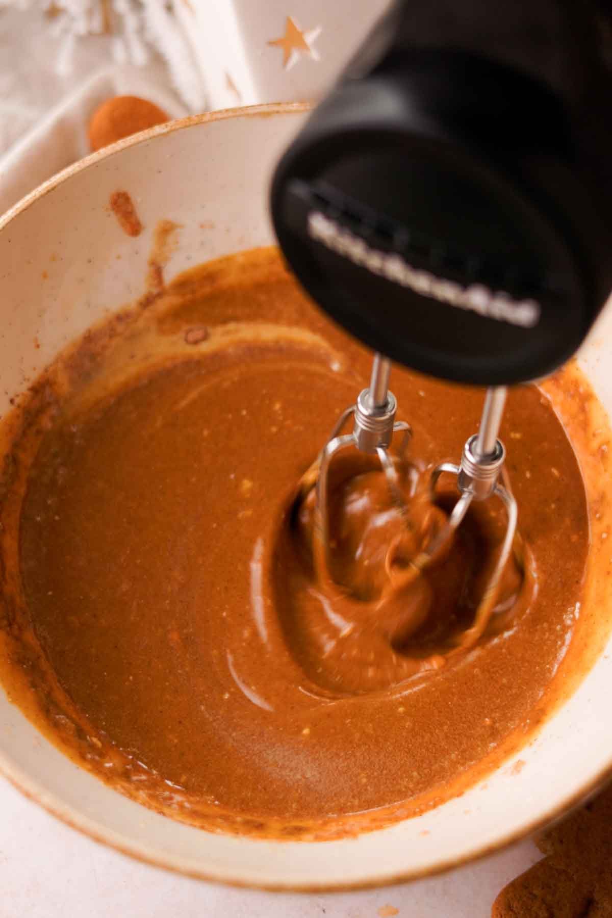 using electric mixer to beat wet ingredients for gingerbread batter together