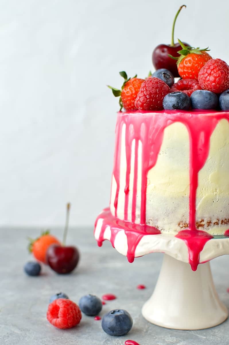 Mini white chocolate berry drip cake - delicious, moist vanilla cake with whipped white chocolate gananche, pink white chocolate drip and fresh berries; serves just 2-4 people!