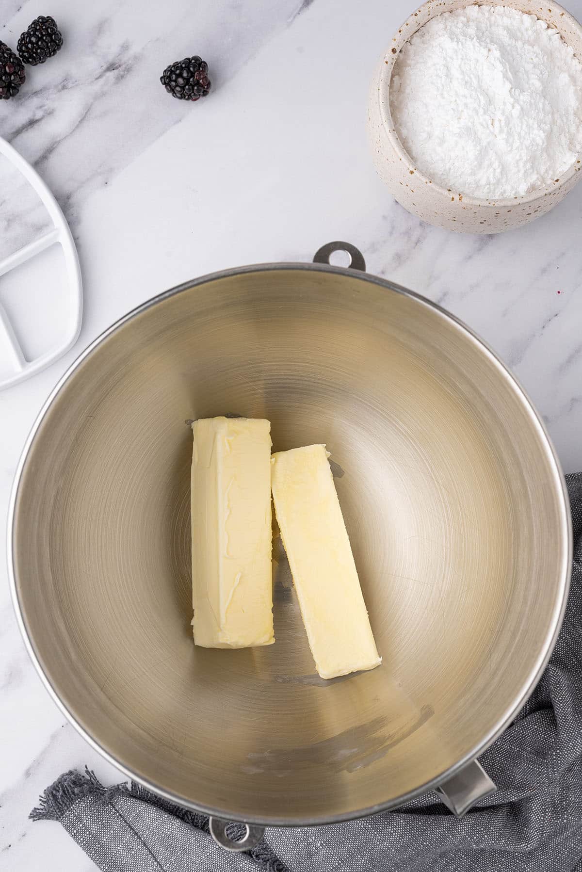 two sticks of butter in bowl of a stand mixer.