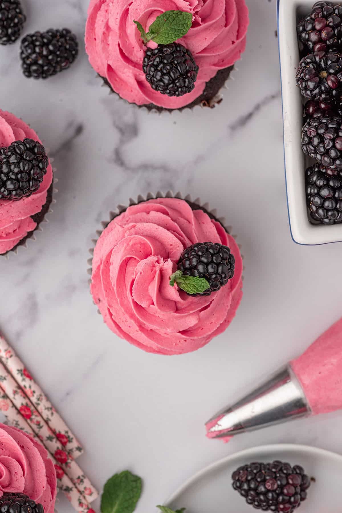 overhead of cupcakes frosted with blackberry buttercream frosting.