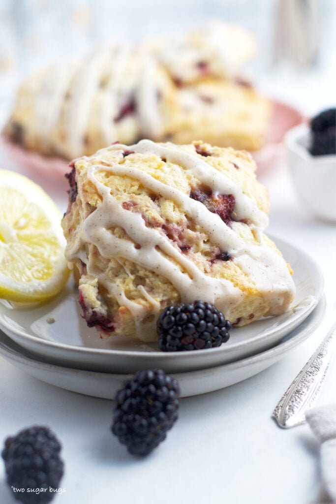 berry scone on a plate with a tray of scones in the background