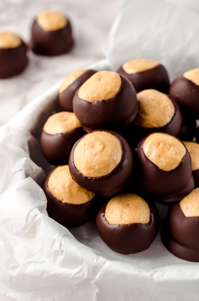 Buckeye balls in a bowl with parchment lining the bowl.