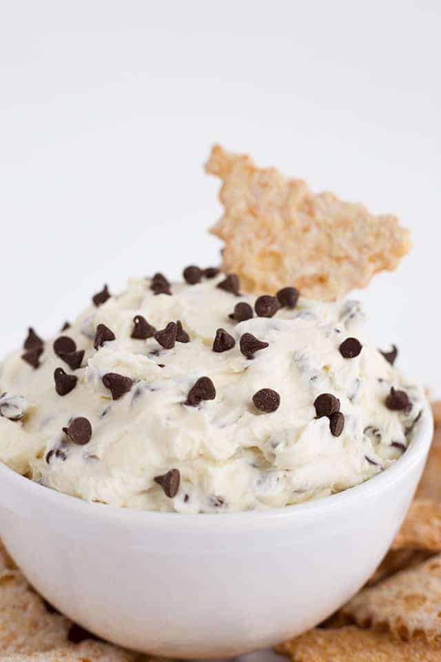 Easy Cannoli Dip Recipe - This Cannoli Dip is such a unique dessert dip. It tastes just like cannoli filling with mascarpone cheese, mini semi-sweet chocolate chip, and ricotta. This thick, sweet dip can be served up with cannoli chips or waffle cone pieces dusted with powdered sugar. #cookiedoughandovenmitt #cannoli #dips #dessert #dessertrecipes #sweets #dessertfoodrecipes #dessertrecipes #partyfood #datenight #appetizers