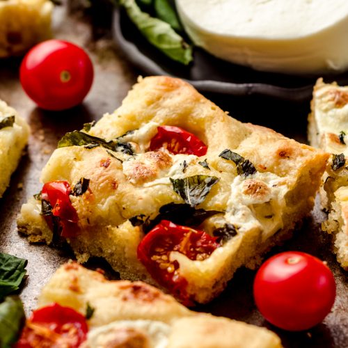 Caprese focaccia slice on a baking sheet.