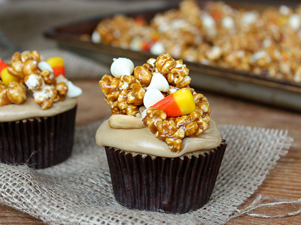 Caramel Corn Cupcakes for Halloween - caramel cupcakes topped with caramel frosting and caramel popcorn studded with candy corn and cashews | by Lauren Kapeluck for TheCakeBlog.com