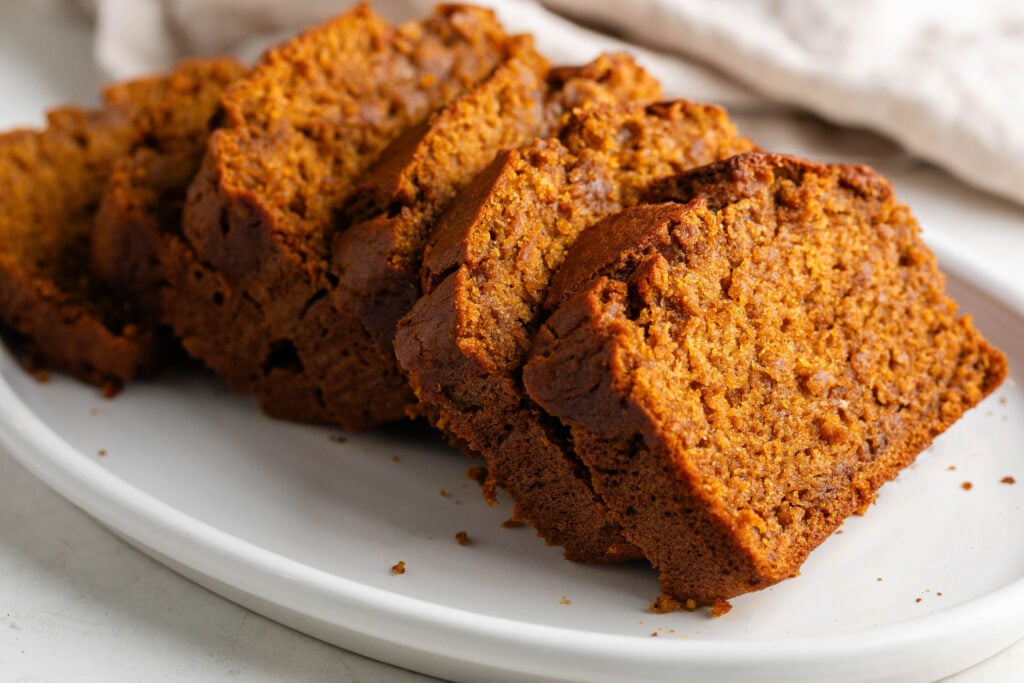 chai latte pumpkin spice bread sliced on a white plate