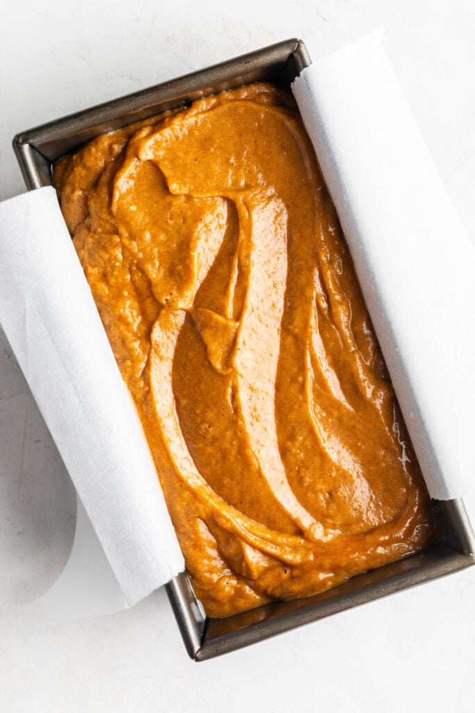 chai latte pumpkin spice bread batter in a parchment lined bread pan