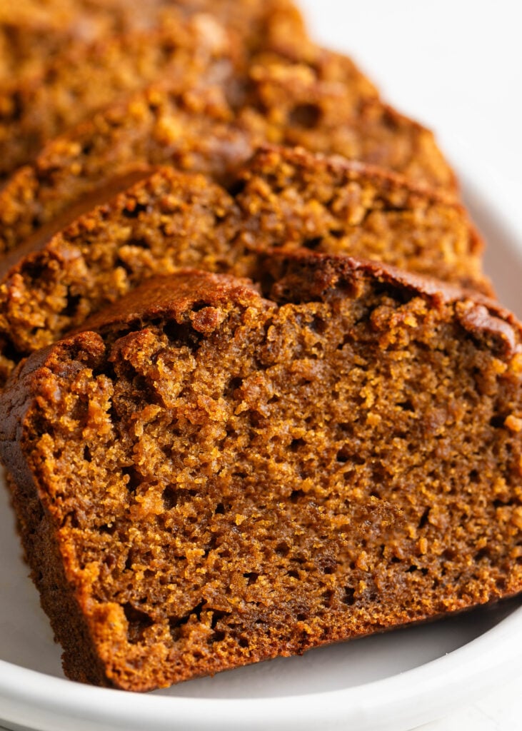 chai latte pumpkin spice bread sliced on a white plate