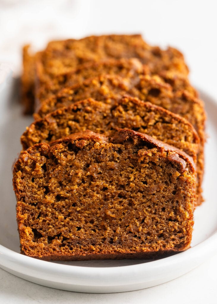 chai latte pumpkin spice bread sliced on a white plate