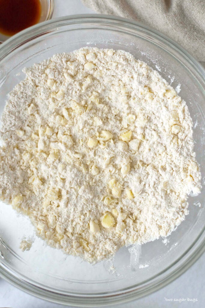 bowl with butter cut into dry ingredients showing a meal like texture