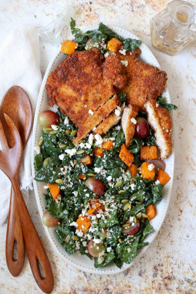 chicken schnitzel and kale autumn salad on platter with serving set 