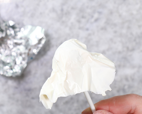 Chocolate Lollipop Ghosts - how to make edible lollipop ghosts for Halloween cakes and cupcakes using white chocolate and suckers | by Erin Gardner for TheCakeBlog.com
