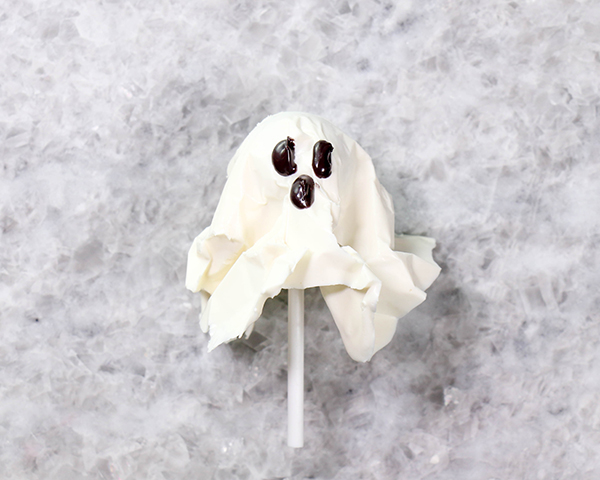 Chocolate Lollipop Ghosts - how to make edible lollipop ghosts for Halloween cakes and cupcakes using white chocolate and suckers | by Erin Gardner for TheCakeBlog.com