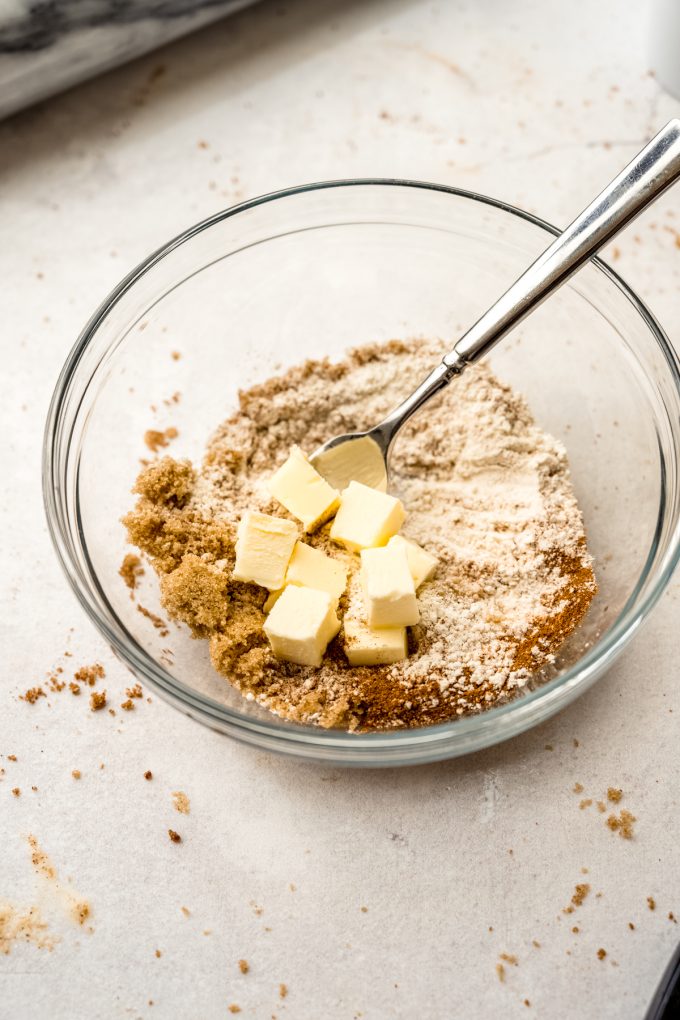 A bowl of ingredients to make cinnamon streusel topping with a fork in it.
